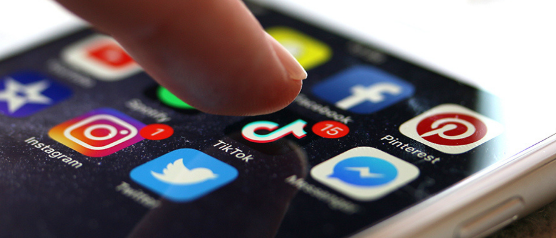 Finger tippt auf einen Handybildschrim auf dem Apps angezeigt werden