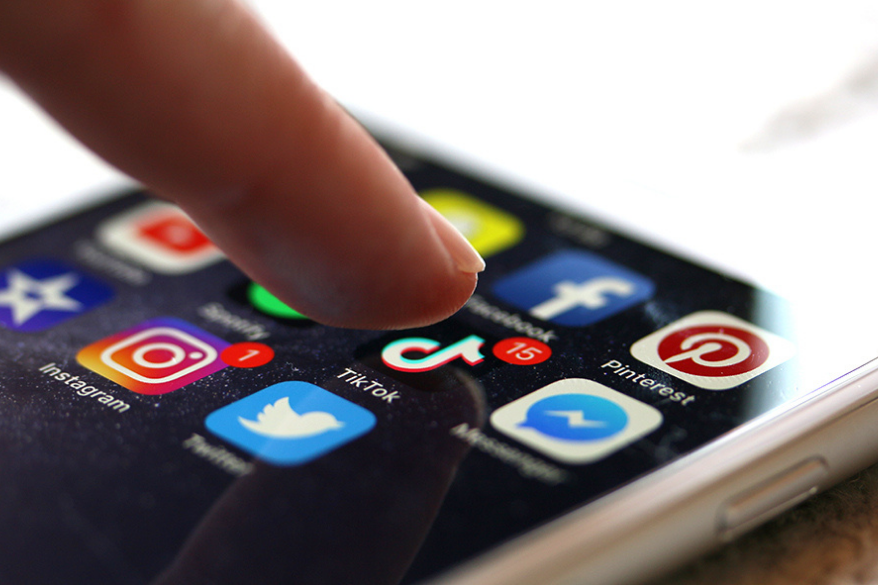 Finger tippt auf einen Handybildschrim auf dem Apps angezeigt werden