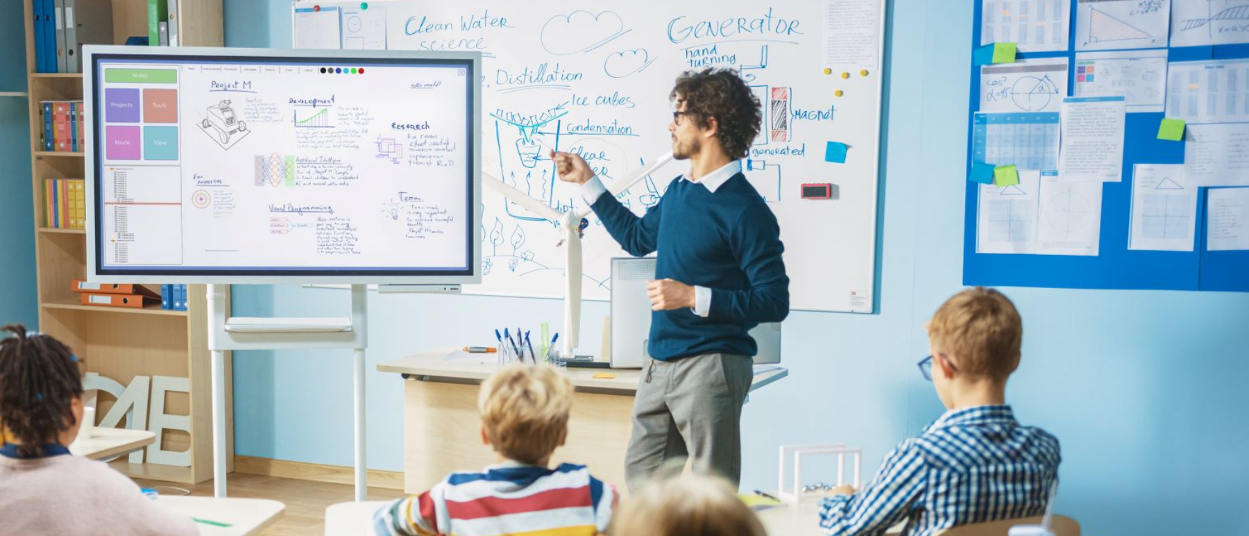 Lehrer steht an einer Tafel vor seiner Schulklasse
