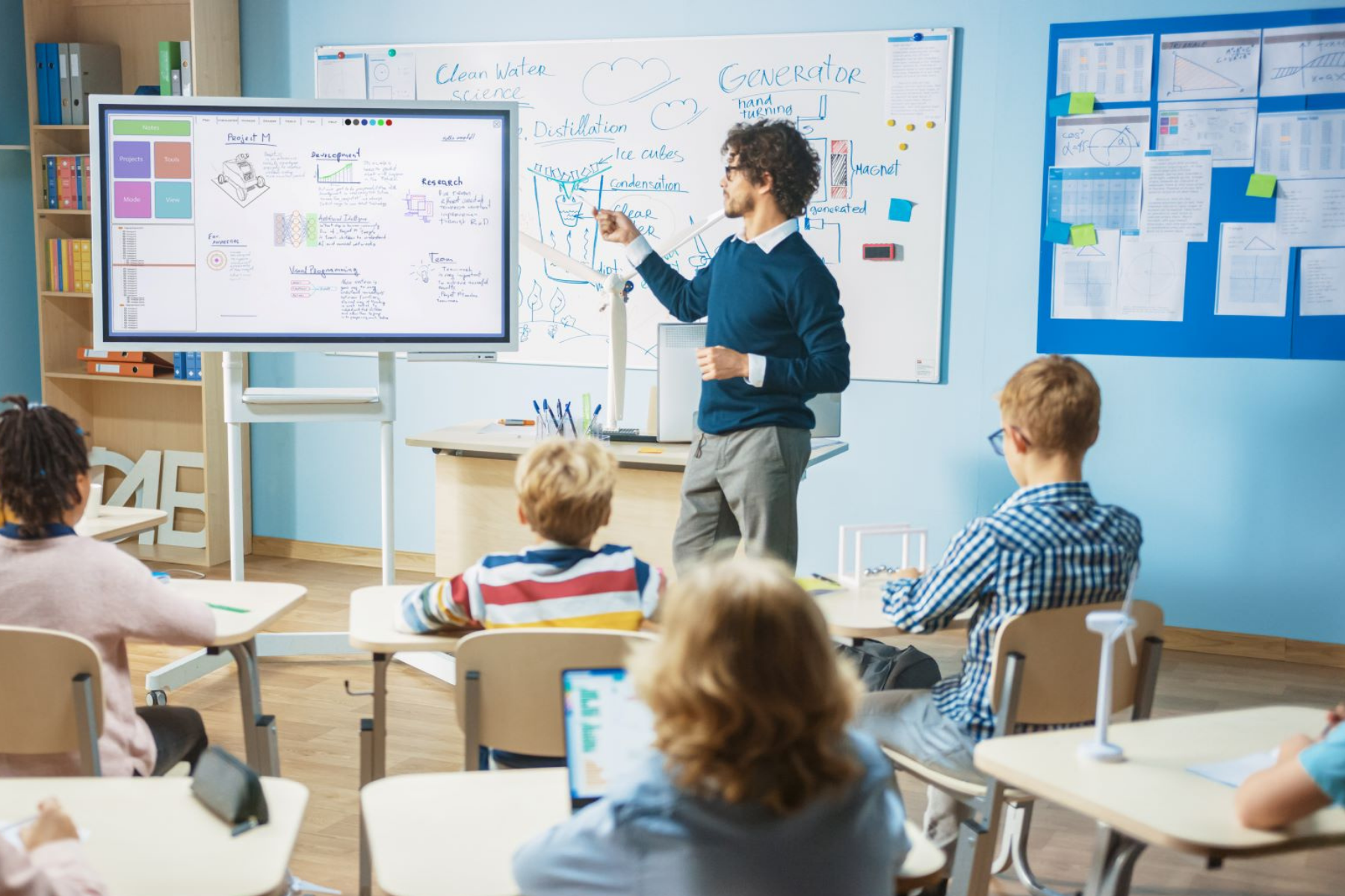 Lehrer steht an einer Tafel vor seiner Schulklasse