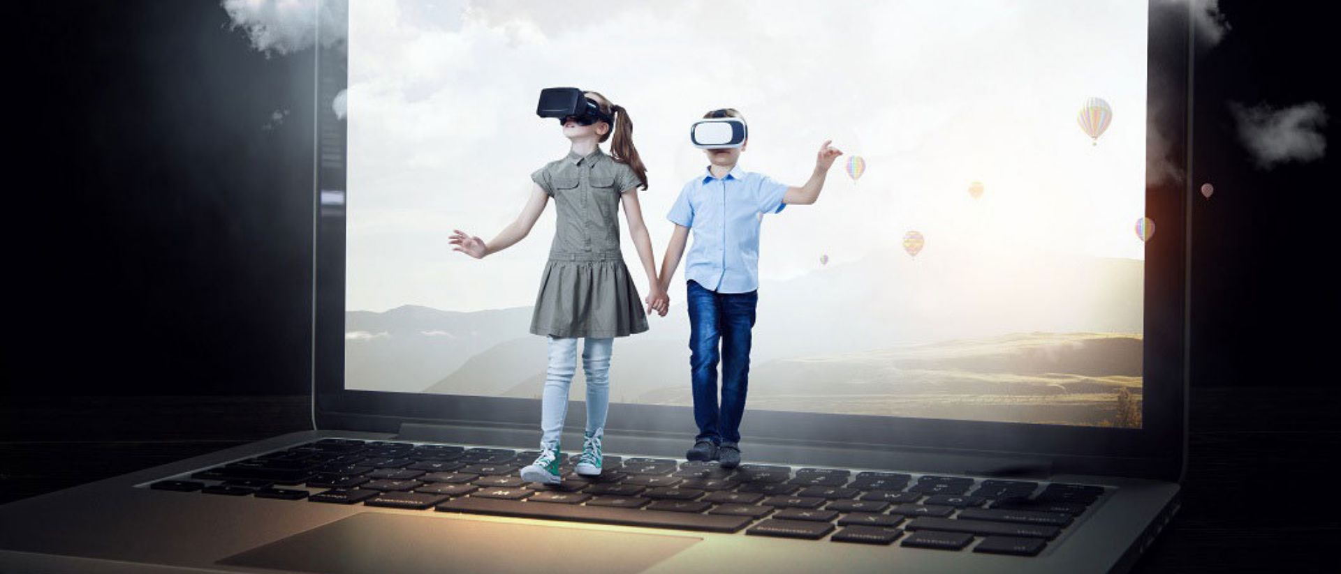 Zwei Kinder mit VR-Brillen stehen auf einem übergroßen Laptop
