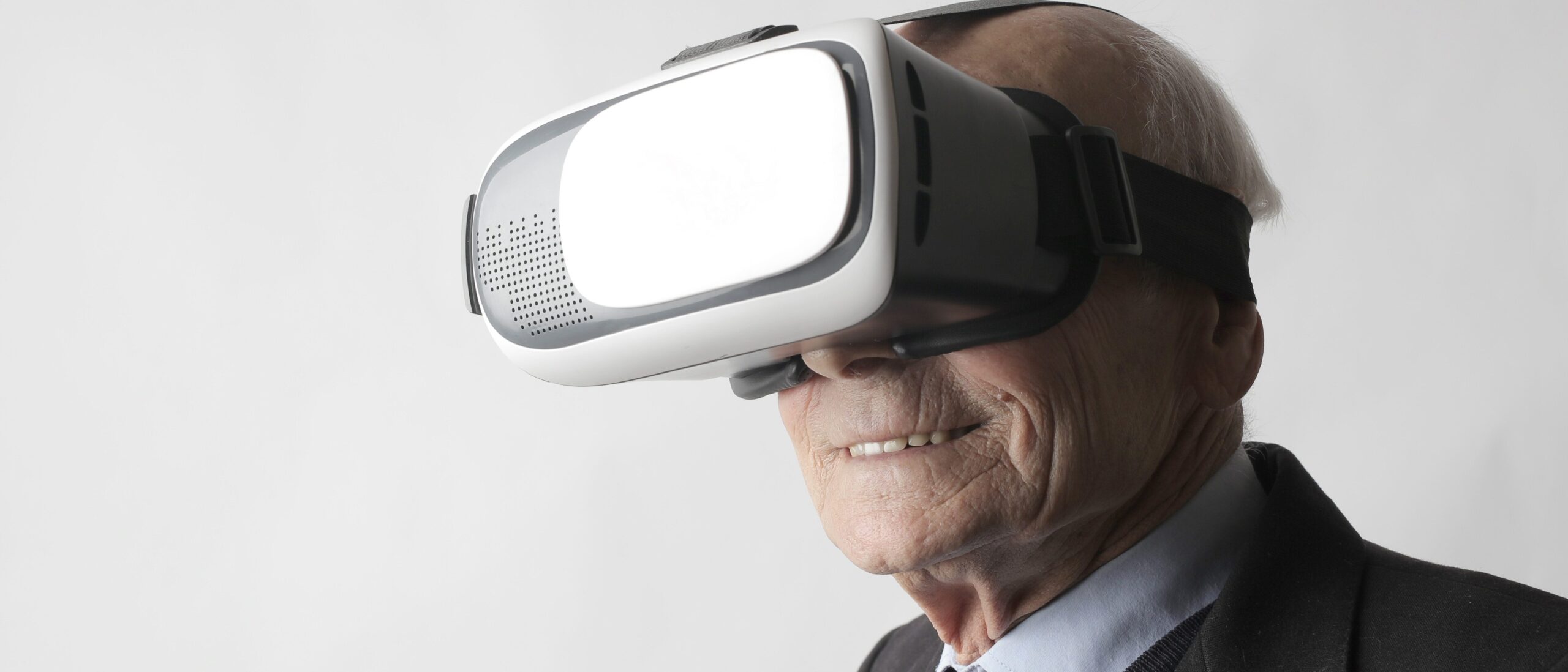 Älterer Herr, der lächelnd eine VR-Brille trägt