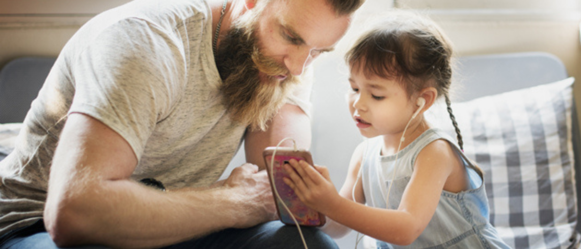 Vater schaut mit seiner Tochter gemeinsam in ein Handy