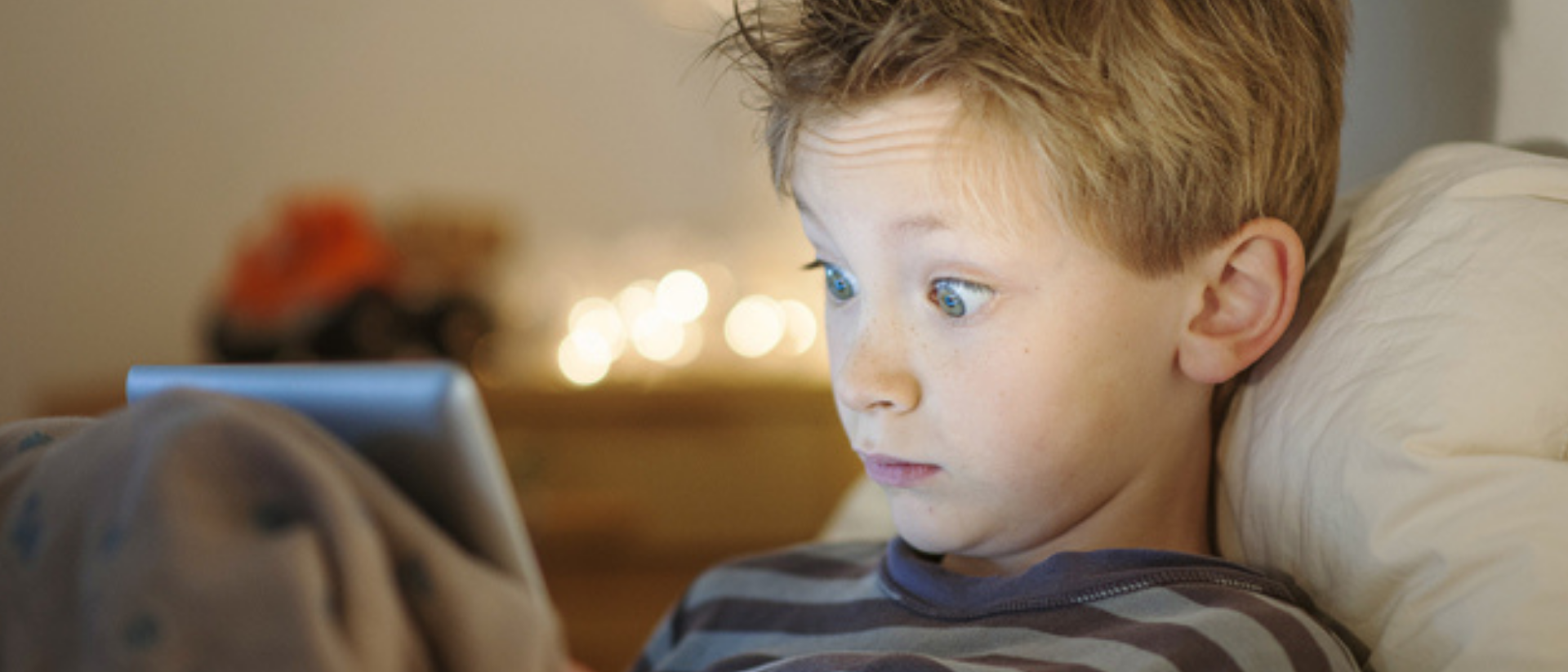 Kleiner Junge schaut erschrocken in sein Tablet