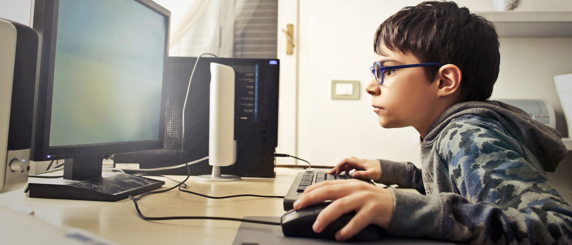 Junge sitzt am PC und zockt.