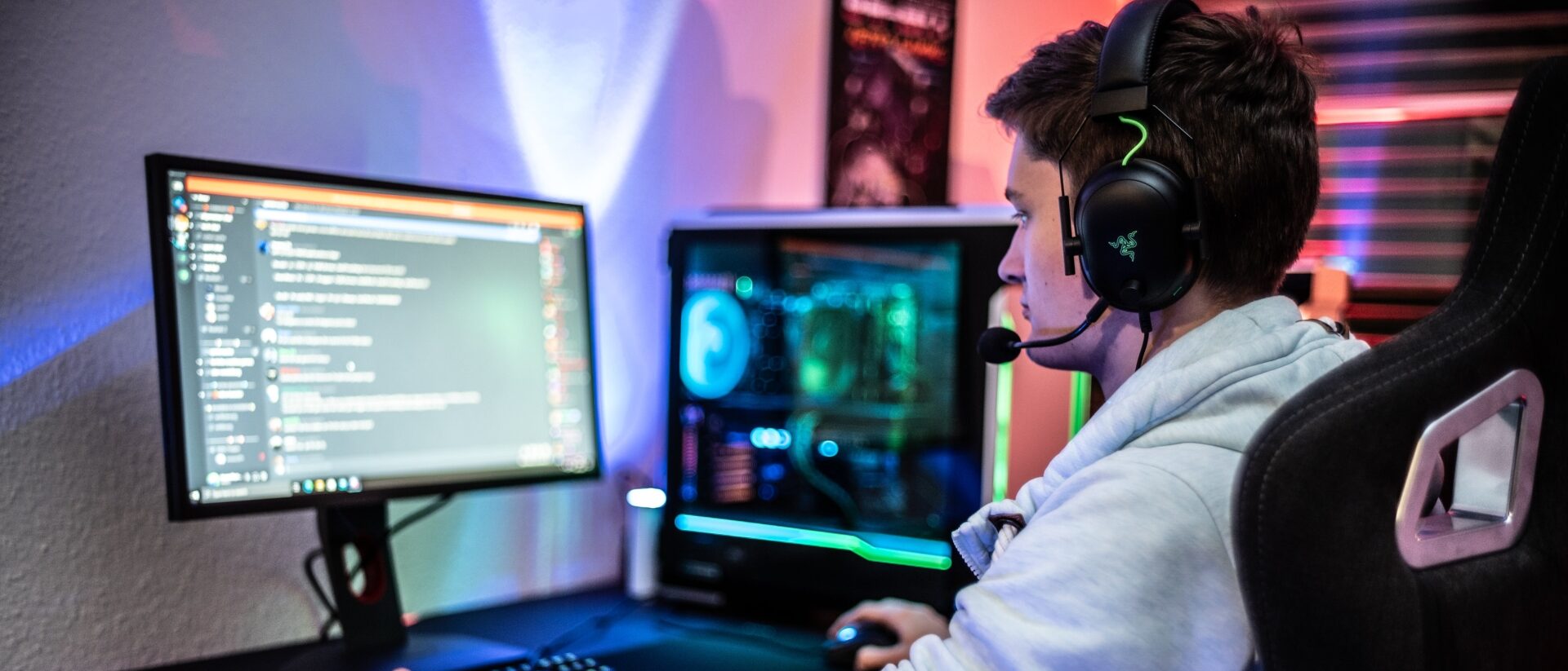 Jungendlichre sitzt im Gamingstuhl vor seonem PC.