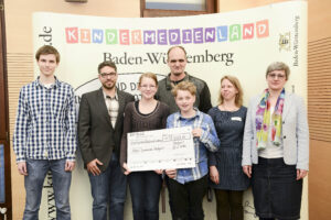 Preisträger'innen halten großen Scheck in der Hand