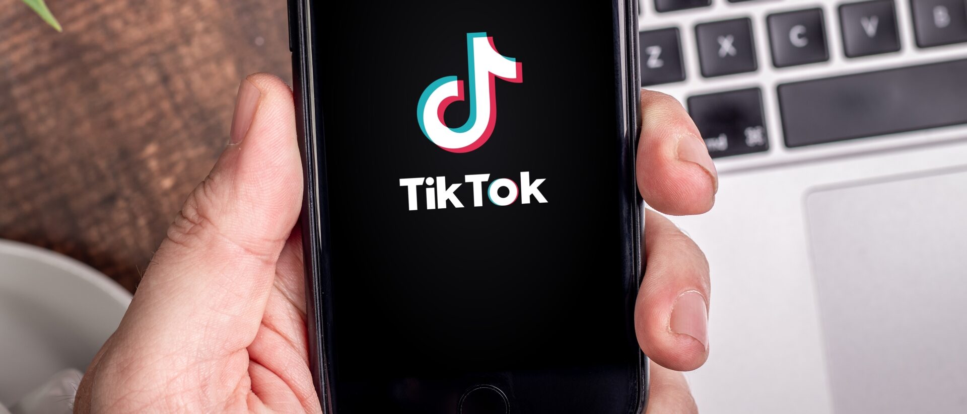 Handy mit TikTok Startscreen wird in der Hand gehalten