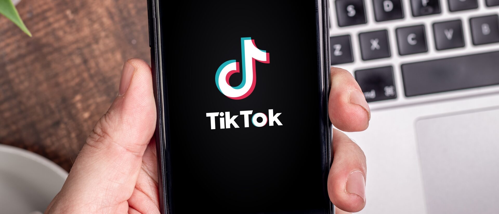 Handy mit TikTok Startscreen wird in der Hand gehalten