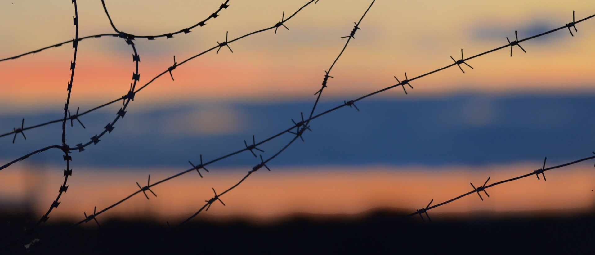 Ein Stacheldrahtzaun vor dem Horizont