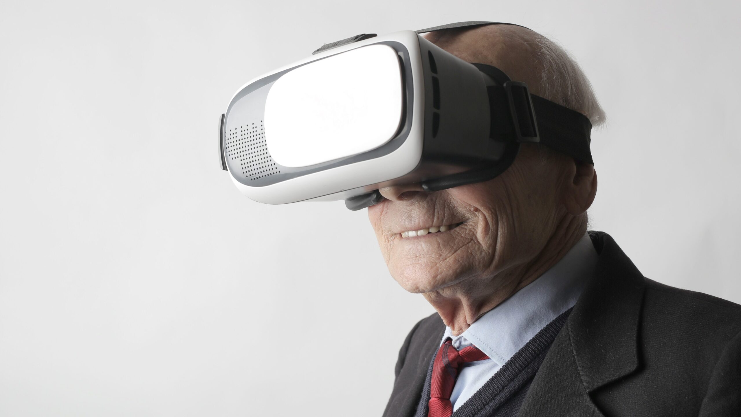 Älterer Herr, der lächelnd eine VR-Brille trägt
