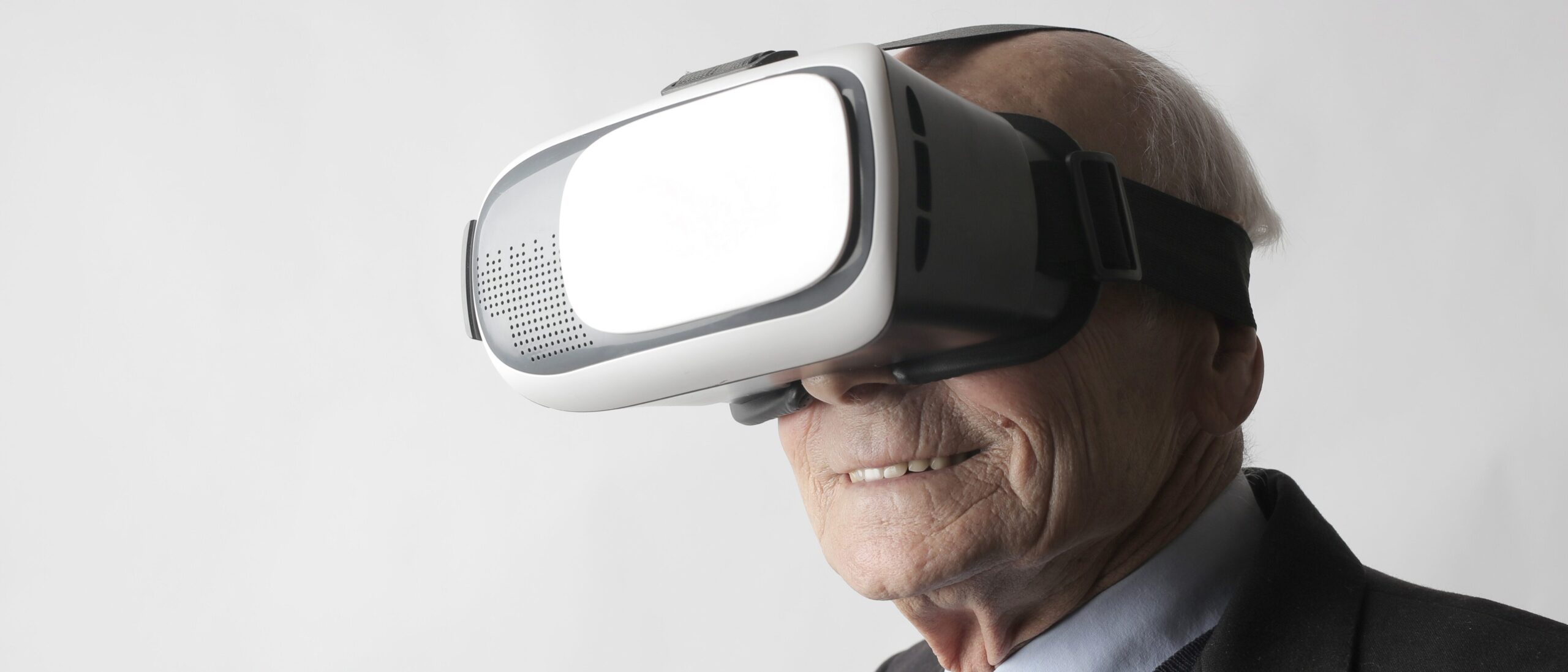Älterer Herr, der lächelnd eine VR-Brille trägt