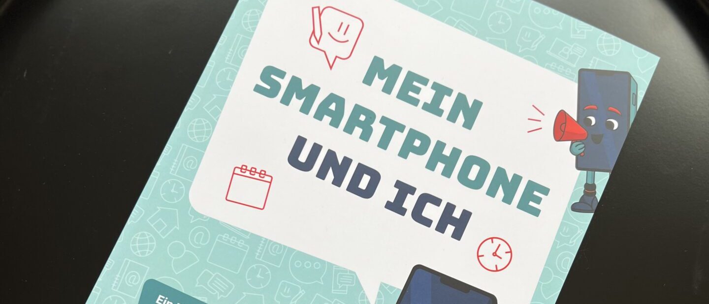 Das Arbeitsheft "Mein Smartphone und ich" liegt in einer Pfanne.
