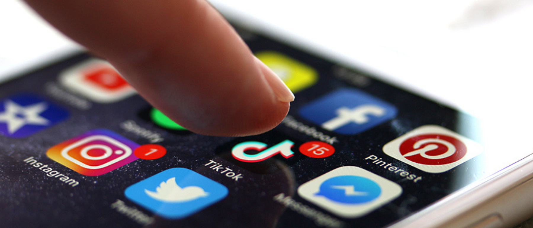Finger tippt auf einen Handybildschrim auf dem Apps angezeigt werden