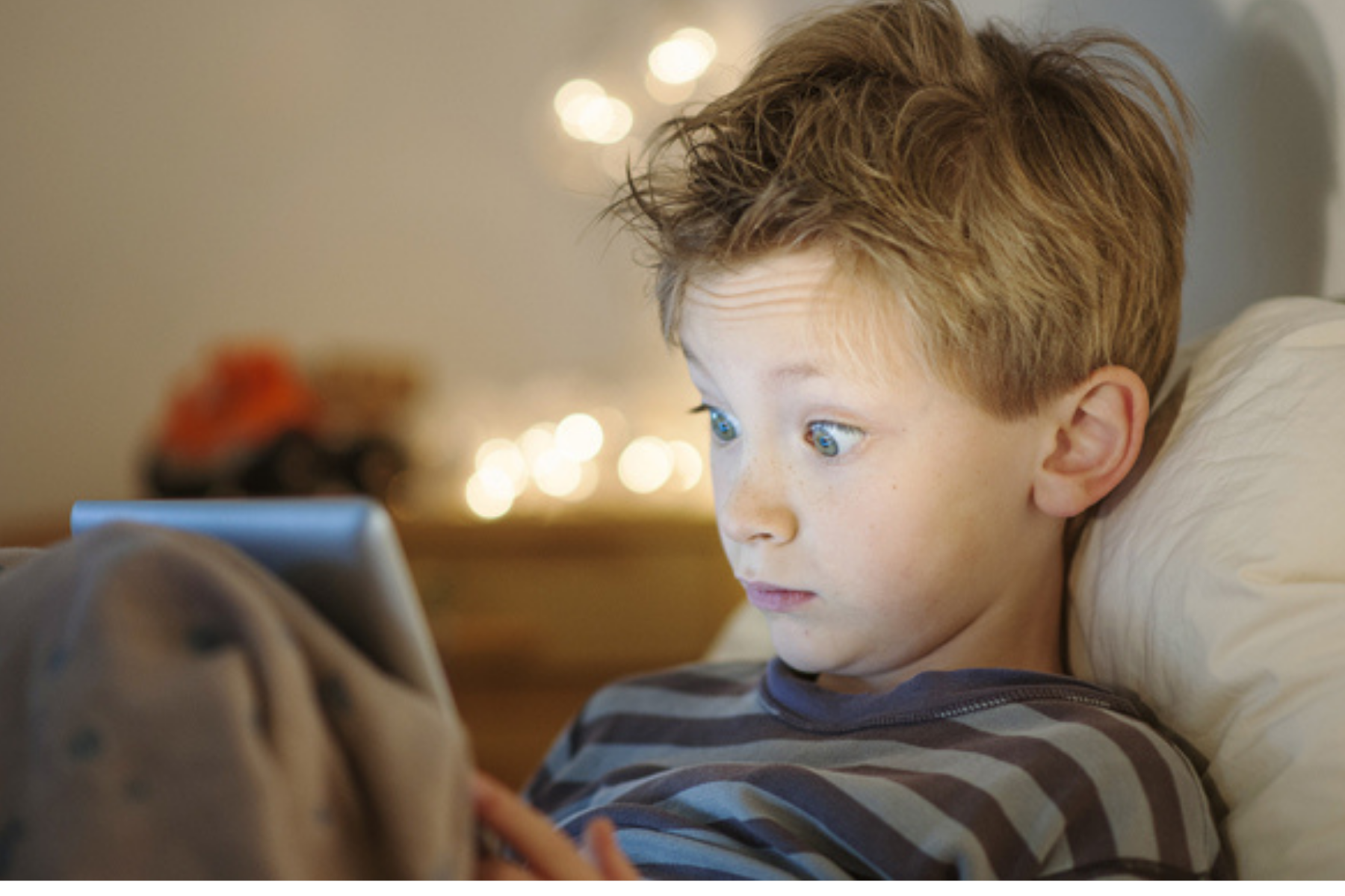 Kleiner Junge schaut erschrocken in sein Tablet